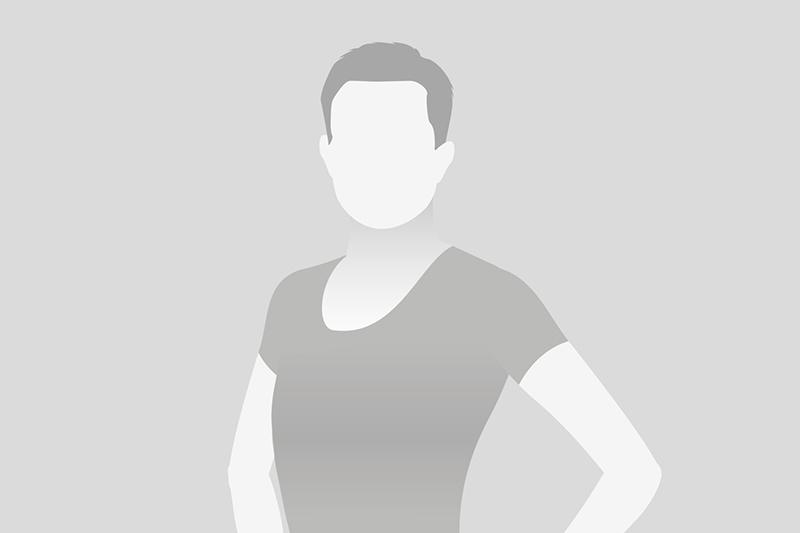 Eine umschattete Silhouette einer Person steht mit verschränkten Armen vor einem neutralen, grauen Hintergrund.