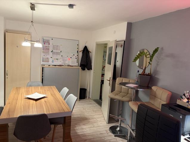 Essbereich mit Holz-Tisch, St&uuml;hlen, Pflanzen und Whiteboard in modernem, freundlich eingerichteten Raum.